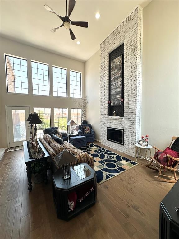 living room featuring a fireplace, hardwood / wood-style flooring, plenty of natural light, and ceiling fan