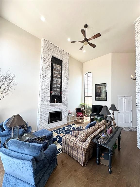 living room with a large fireplace, ceiling fan, and hardwood / wood-style floors