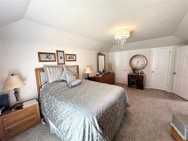 bedroom featuring carpet, an inviting chandelier, and lofted ceiling