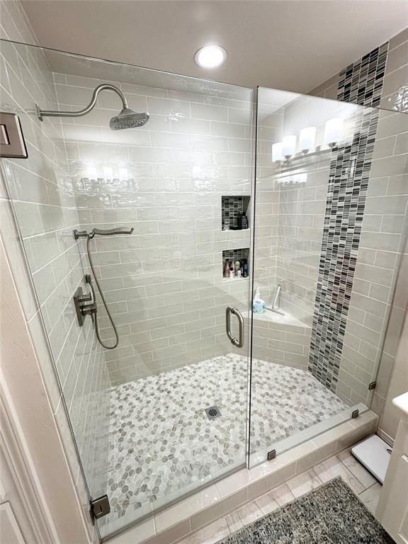 bathroom featuring tile patterned flooring and an enclosed shower