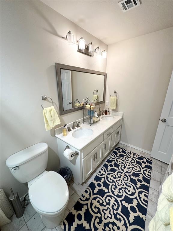 bathroom with tile patterned flooring, vanity, and toilet