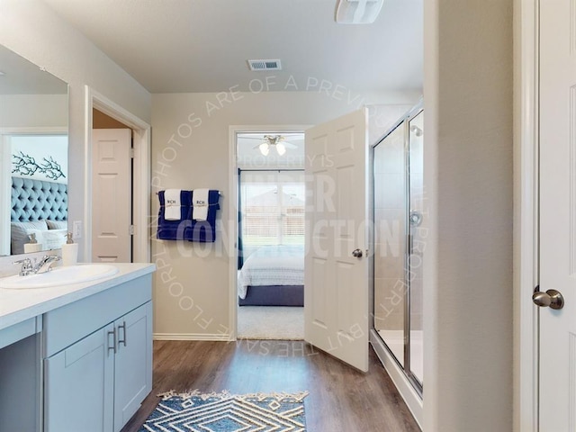 bathroom with hardwood / wood-style floors, vanity, walk in shower, and ceiling fan