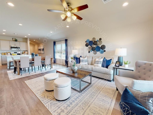 living room with ceiling fan and light hardwood / wood-style flooring