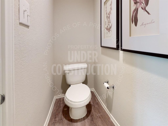 bathroom with hardwood / wood-style flooring and toilet