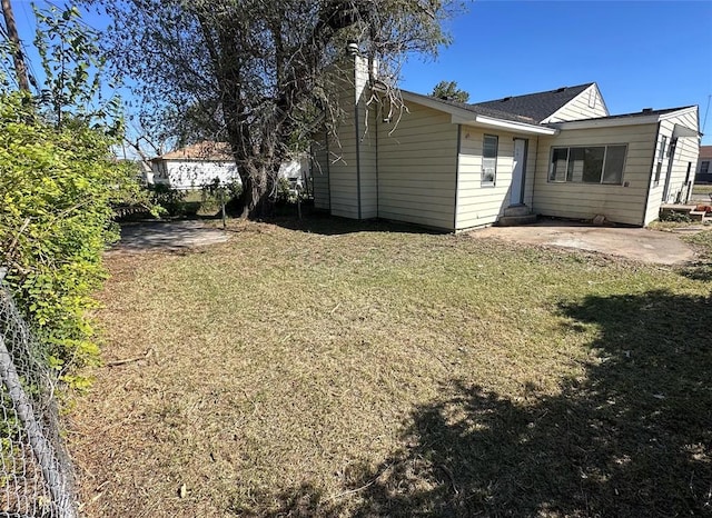 view of property exterior with a yard and a patio