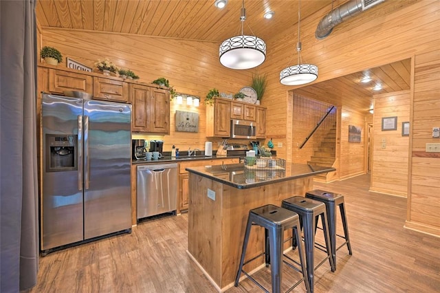 kitchen featuring sink, hanging light fixtures, a kitchen island, wood ceiling, and appliances with stainless steel finishes