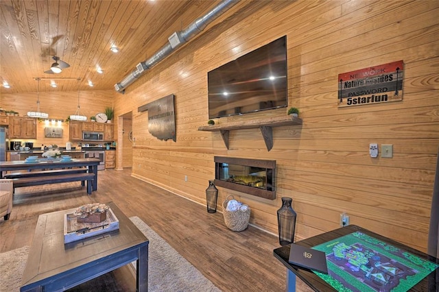 living room with wood-type flooring, wooden ceiling, and wood walls