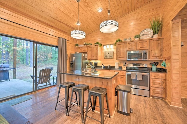 kitchen featuring wooden ceiling, pendant lighting, wooden walls, a kitchen island, and appliances with stainless steel finishes