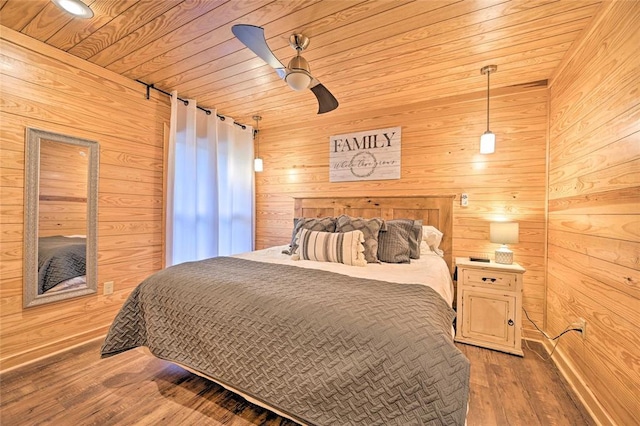 bedroom with ceiling fan, wooden walls, wood-type flooring, and wooden ceiling