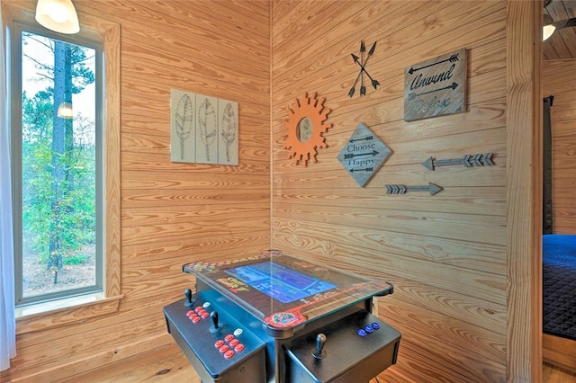 rec room with wooden walls and wood-type flooring