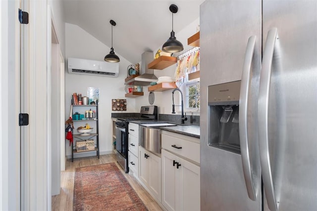 kitchen featuring lofted ceiling, wall chimney exhaust hood, white cabinetry, stainless steel appliances, and a wall unit AC