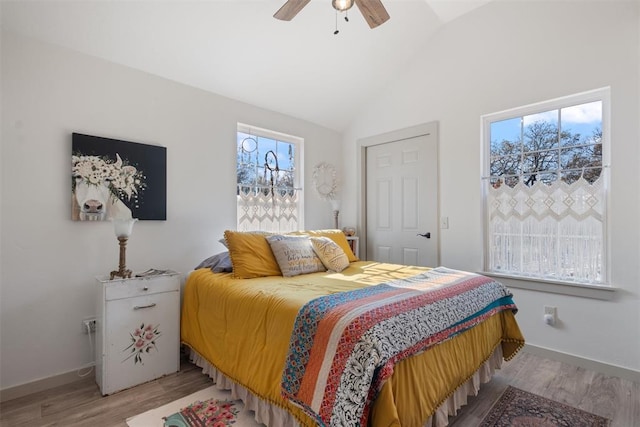 bedroom with ceiling fan, vaulted ceiling, and light hardwood / wood-style flooring