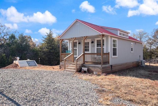 view of front facade with covered porch and central AC