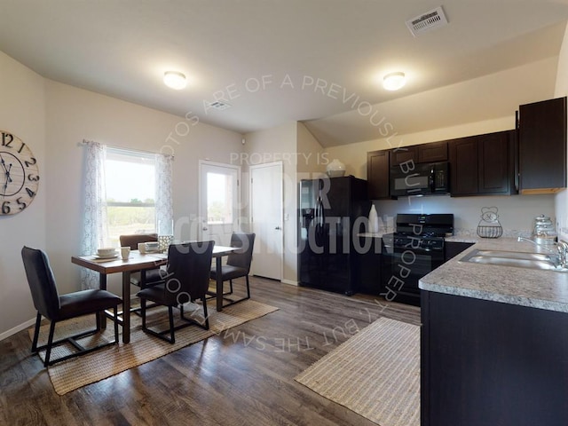 kitchen with dark brown cabinets, dark wood-type flooring, black appliances, and sink