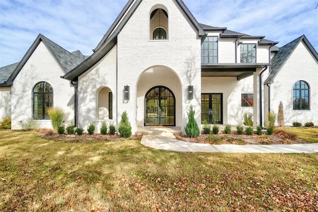 view of front facade with french doors and a front lawn