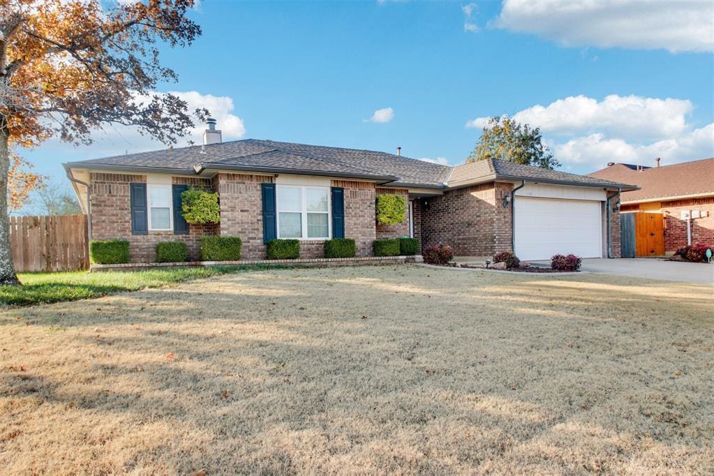 ranch-style house featuring a front lawn and a garage