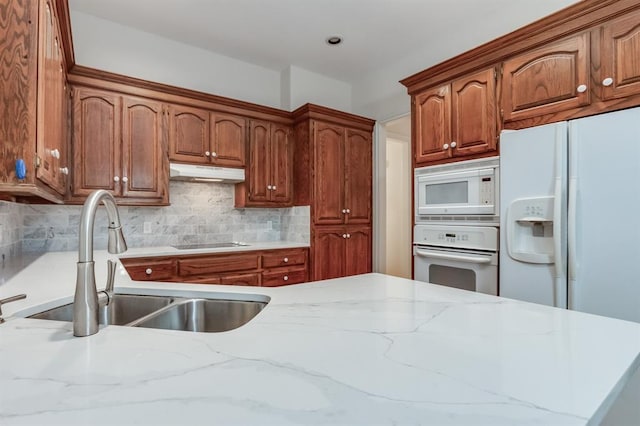 kitchen with decorative backsplash, white appliances, and sink