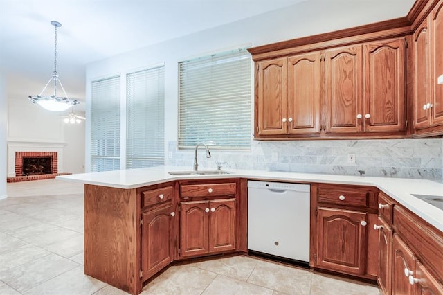 kitchen with a brick fireplace, sink, decorative light fixtures, dishwasher, and light tile patterned flooring