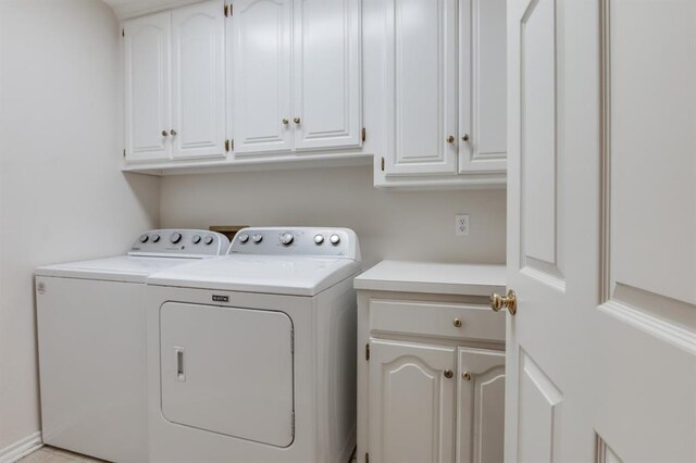 laundry room with cabinets and washing machine and clothes dryer