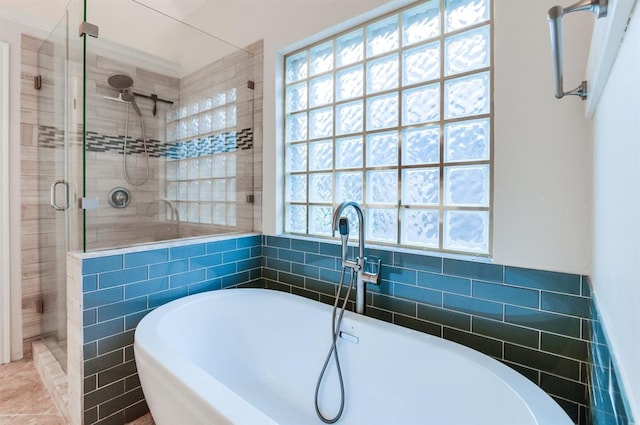 bathroom with tile patterned flooring, a healthy amount of sunlight, shower with separate bathtub, and tile walls