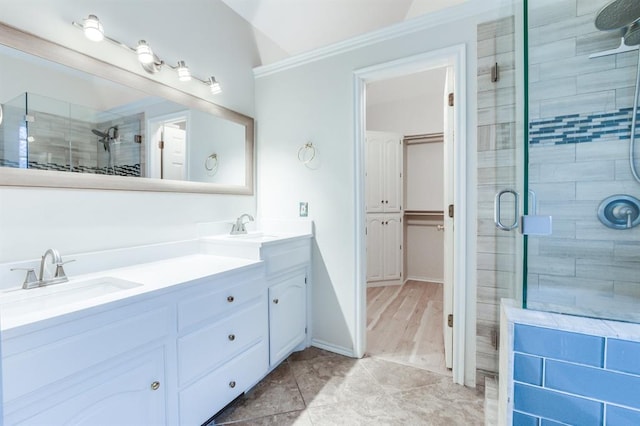 bathroom with vanity, crown molding, wood-type flooring, and a shower with door