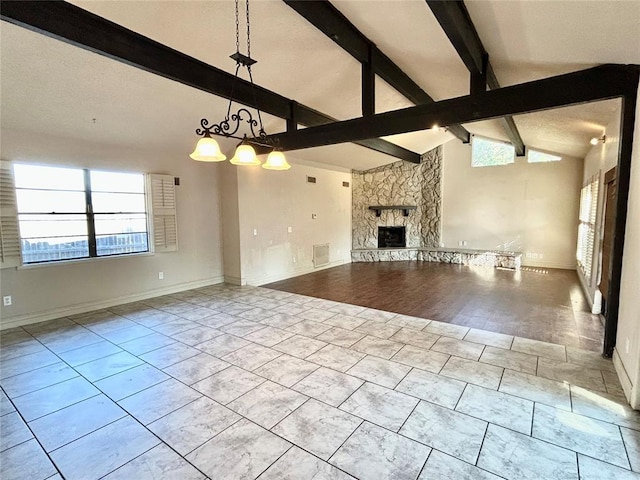 unfurnished living room with vaulted ceiling with beams, light hardwood / wood-style flooring, plenty of natural light, and a stone fireplace