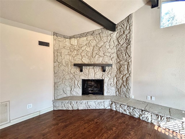 unfurnished living room featuring a stone fireplace, lofted ceiling with beams, and wood-type flooring