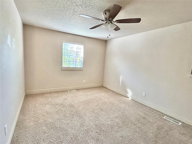 spare room featuring carpet flooring, ceiling fan, and a textured ceiling