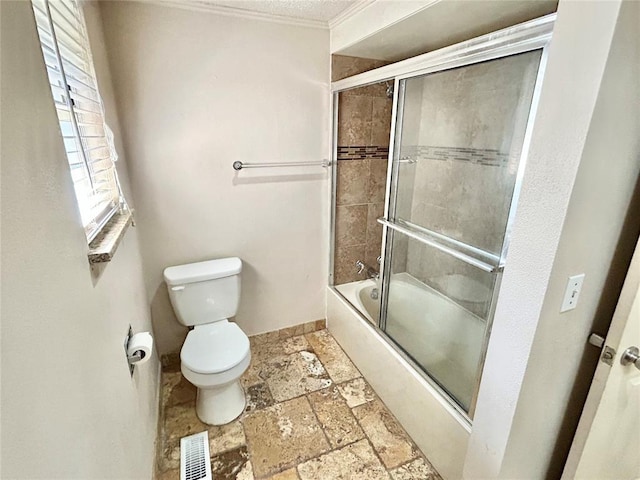 bathroom with toilet, ornamental molding, and combined bath / shower with glass door