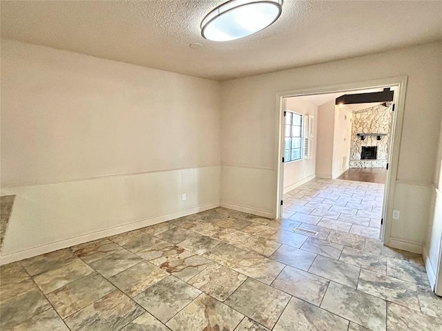 unfurnished room featuring a fireplace and a textured ceiling