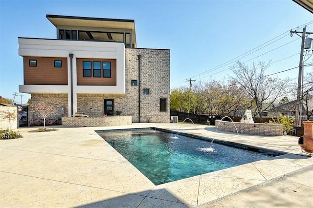 back of house featuring pool water feature, a fenced in pool, and a patio