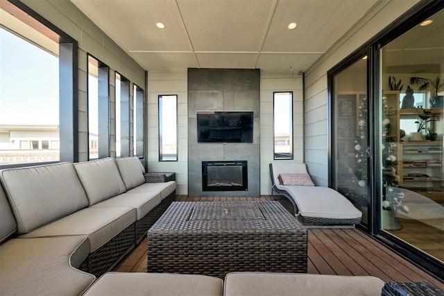 sunroom / solarium featuring plenty of natural light and a large fireplace