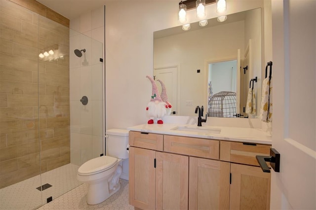 bathroom featuring tile patterned flooring, vanity, toilet, and tiled shower