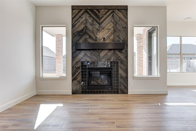 unfurnished living room with a fireplace and light wood-type flooring