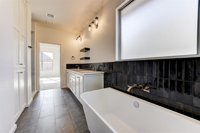 bathroom with tile patterned flooring, vanity, and a bathing tub