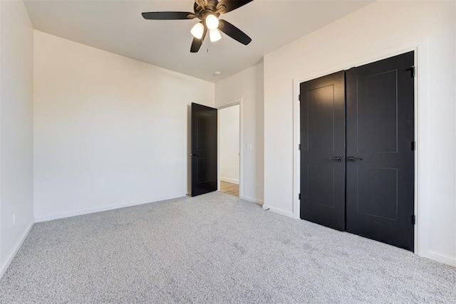 unfurnished bedroom with ceiling fan, a closet, and light colored carpet