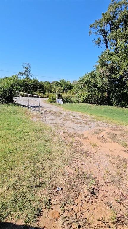 view of yard featuring a view of rural / pastoral area and dirt driveway