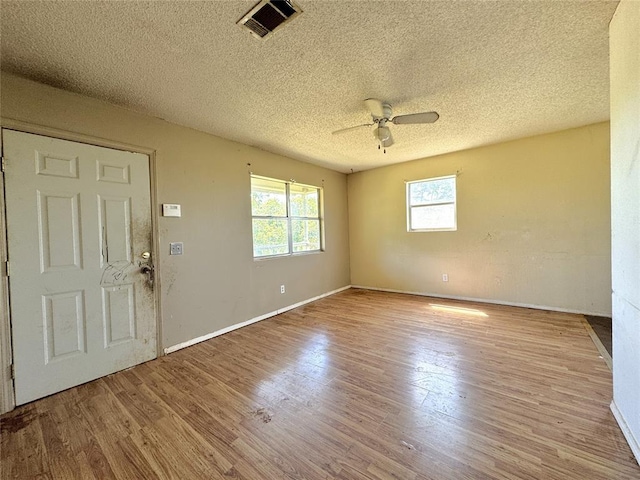 entryway with a ceiling fan, a textured ceiling, wood finished floors, and baseboards