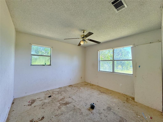 spare room featuring plenty of natural light, a textured ceiling, and a ceiling fan