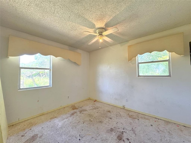 carpeted spare room with a ceiling fan, a textured ceiling, and baseboards