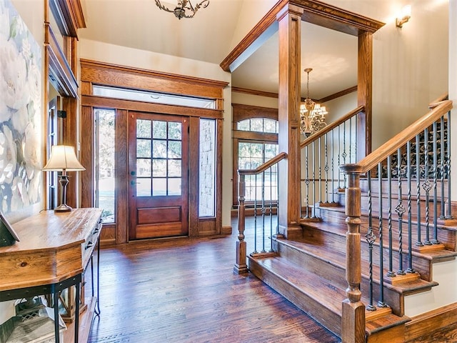 entryway with a notable chandelier, crown molding, and dark wood-type flooring