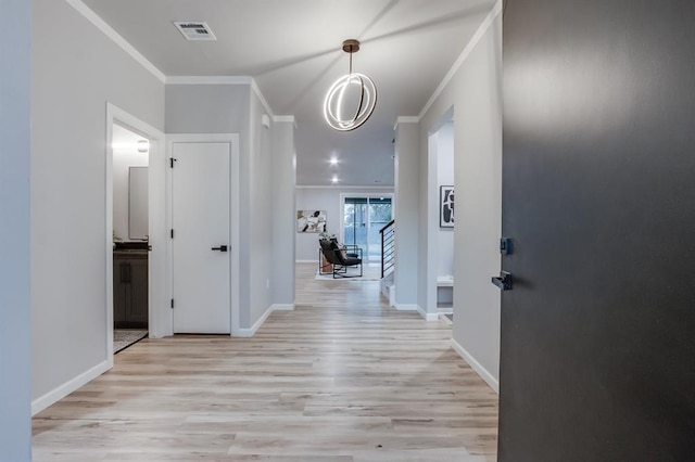 hall featuring ornamental molding and light hardwood / wood-style floors