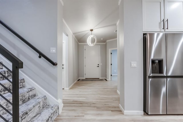 foyer entrance featuring light hardwood / wood-style floors and crown molding