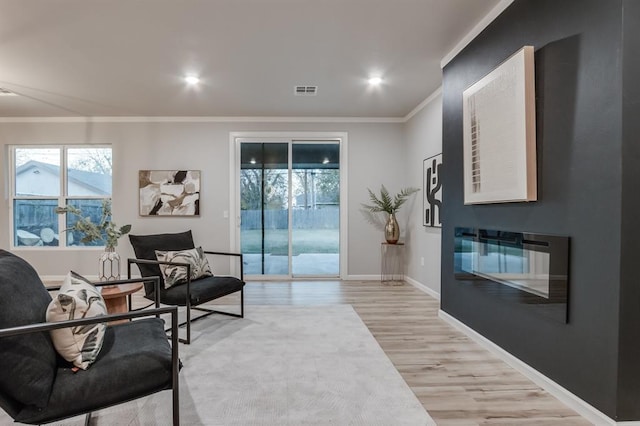 sitting room featuring light hardwood / wood-style floors and ornamental molding