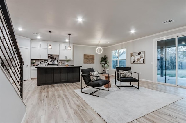 living room with light hardwood / wood-style flooring and crown molding