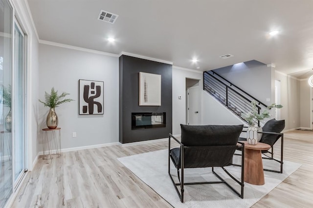 interior space with light hardwood / wood-style floors, ornamental molding, and a fireplace