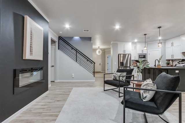 living room with light hardwood / wood-style floors and sink