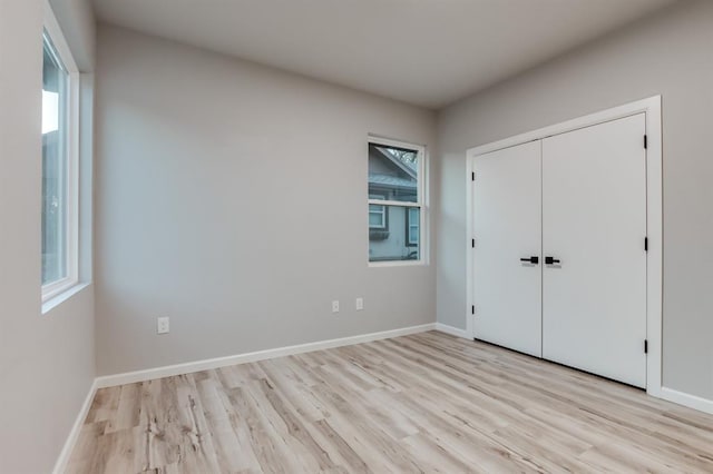 unfurnished bedroom with light hardwood / wood-style flooring and a closet