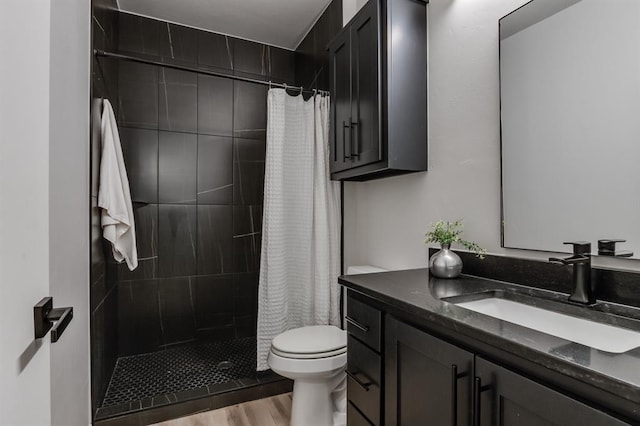 bathroom featuring walk in shower, toilet, vanity, and hardwood / wood-style flooring