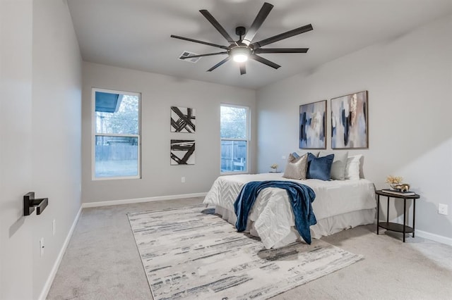 carpeted bedroom featuring multiple windows and ceiling fan